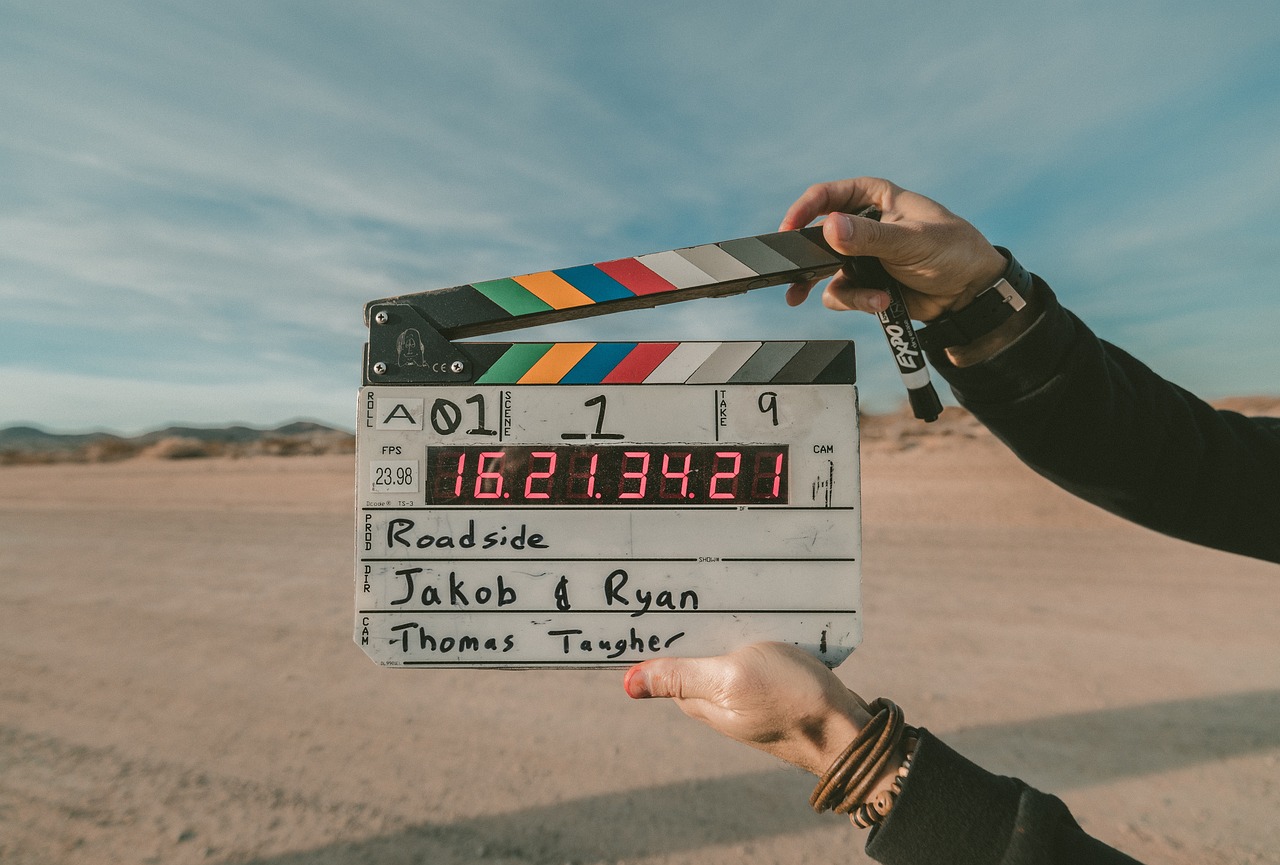 hands holding a movie clapper open ready to close for next scene