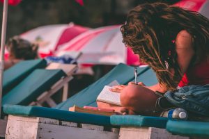 Woman With Red Top Holding Pen and Notebook