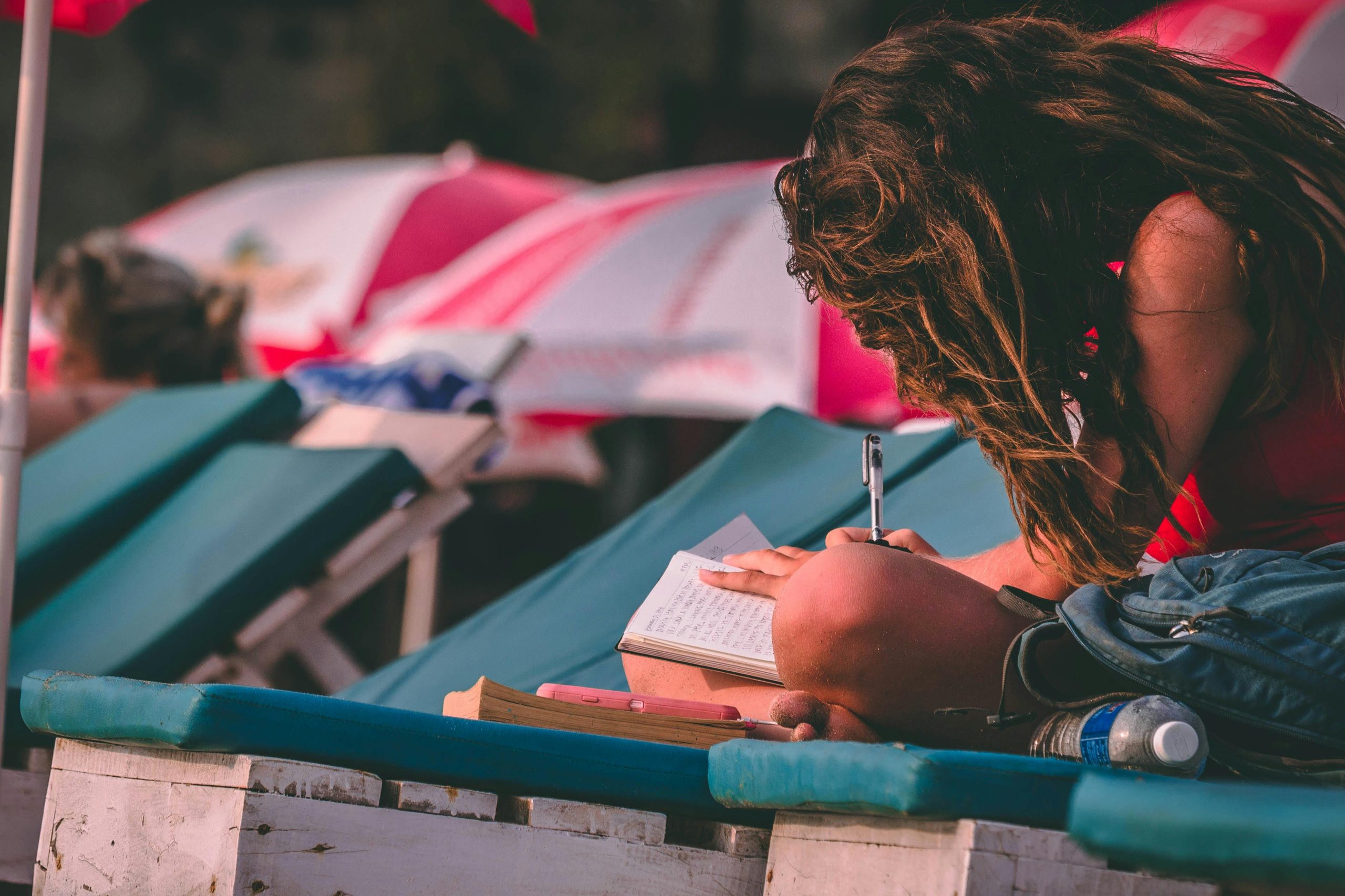 Woman With Red Top Holding Pen and Notebook 