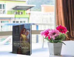 copy of book on a window sill with flowers