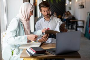 woman and man at desk having a conversation about a document